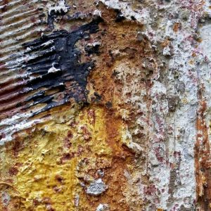 metal wall fond de couleur ocre empâtements couleur blanc reliefs tâche noir au centre de l'oeuvre des stries blanc fond partie de l'ornement des reliefs crées en poudre de marche morceau de photo appartenant à l'oeuvre metal wall qui fut le premier signe et style de ma démarche artistique actuelle